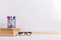 Books, markers, notebook, pencil and glasses on the table against the background of a white board. Copy space Royalty Free Stock Photo