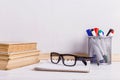 Books, markers, notebook, pencil and glasses on the table against the background of a white board. Copy space Royalty Free Stock Photo