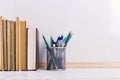 Books, markers, notebook, pencil and glasses on the table against the background of a white board. Copy space Royalty Free Stock Photo