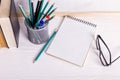 Books, markers, notebook, pencil and glasses on the table against the background of a white board. Copy space Royalty Free Stock Photo