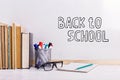 Books, markers, notebook, pencil and glasses on the table against the background of a white board. Copy space Royalty Free Stock Photo