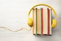 Books and modern headphones on wooden table, top view. Space for text Royalty Free Stock Photo