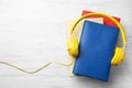 Books and modern headphones on wooden table, top view. Space for text Royalty Free Stock Photo