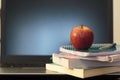 Books, notebook and apple on laptop Royalty Free Stock Photo