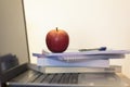 Books, notebook and apple on laptop Royalty Free Stock Photo