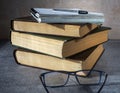 Books and notebooks are stacked. The pen is on top of the notebook. Eyeglasses on the table. Writing a summary, studying Royalty Free Stock Photo