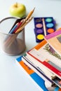 The books, pencils, and apples on the table