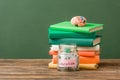 Books, piggy bank and brain on wooden surface Royalty Free Stock Photo