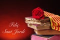 Books, red rose and the text Felic Sant Jordi, Happy Saint Georg Royalty Free Stock Photo