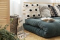 Books on scandinavian green futon with pillows, real photo