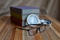 Books stacked and glasses are lying on table Royalty Free Stock Photo