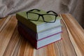 Books stacked and glasses are lying on table Royalty Free Stock Photo
