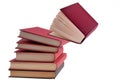 Books stacked with one book falling white background