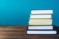 Books on table in front of chalk board.