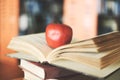 Books on the table in the library - Education learning old book stack on wood desk and blurred bookshelf room background with Royalty Free Stock Photo