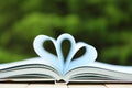 Books on Table With Top One Opened and Pages Forming Heart Royalty Free Stock Photo