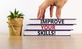 Books with text `improve your skills` on beautiful white table. Male hand, house plant. White background. Business concept. Copy Royalty Free Stock Photo