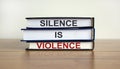 Books with text `silence is violence` on beautiful wooden table. White background. Business concept Royalty Free Stock Photo
