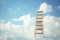 Books on a wooden ladder against a blue sky with clouds. Education concept, book stack with ladder on sky with clouds backgrou