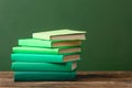 Books on wooden surface isolated on green Royalty Free Stock Photo