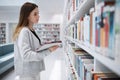 Bookshelf, student or woman in library search for research, education or learning on tablet. Scholarship, study or girl Royalty Free Stock Photo