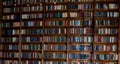 Bookshelves in the library. Book background. Large bookcase with lots of books. Sofa in the room for reading books. Library or