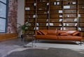 Bookshelves in the library. Large bookcase with lots of books. Sofa in the room for reading books. Library or shop with Royalty Free Stock Photo