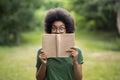 Bookworm. Funny African American Student Girl Standing Outdoors Covering Face With Book Royalty Free Stock Photo