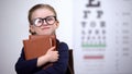 Bookworm kid in glasses hugging books, poor vision after reading too much