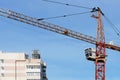 Boom crane on the construction of a high-rise building. Blue sky, high-rise building, construction, close-up, crane operator`s Royalty Free Stock Photo