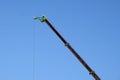 Boom crane manipulator high in the blue cloudless sky