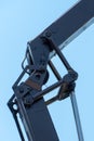 Boom of a tower crane in close-up against the blue sky. A working crane on a construction site. View of the crane hook, cables and Royalty Free Stock Photo