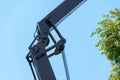 Boom of a tower crane in close-up against the blue sky. A working crane on a construction site. View of the crane hook, cables and