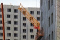 The boom of a tower crane among a residential complex of buildings under construction on a spring day. Real estate construction Royalty Free Stock Photo