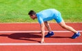 Boost speed concept. Man athlete runner push off starting position stadium path sunny day. Runner captured in motion