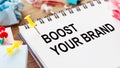 Boost Your Brand Message Written on White Notebook With Pushpins on Wooden Desk Royalty Free Stock Photo