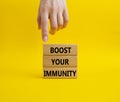 Boost your immunity symbol. Concept word Boost your immunity on wooden blocks. Doctor hand. Beautiful yellow background. Helthcare