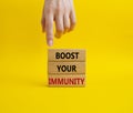 Boost your immunity symbol. Concept word Boost your immunity on wooden blocks. Doctor hand. Beautiful yellow background. Helthcare