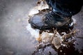 Boot cracking through an ice puddle