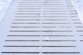 Boot prints left in the snow on a wooden path Royalty Free Stock Photo