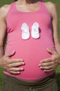 Bootees on tummy pink pregnant Royalty Free Stock Photo