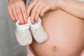 Booties for newborn in the hands of a pregnant girl Royalty Free Stock Photo