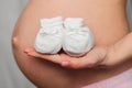 Booties for newborn in the hands of a pregnant girl Royalty Free Stock Photo