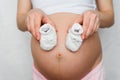 Booties for newborn in the hands of a pregnant girl Royalty Free Stock Photo