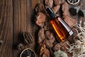 Bootle of oil, moisturizing lotion or other cosmetic product on wooden background with pine bark, moss, citrus, roots.