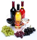 Bootles and glasses of wine with black, red and white grapes Royalty Free Stock Photo