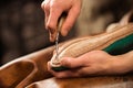 Bootmaker sitting in workshop making shoes