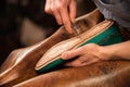 Bootmaker sitting in workshop making shoes