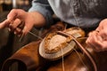 Bootmaker sitting in workshop making shoes