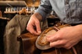 Bootmaker sitting in workshop making shoes